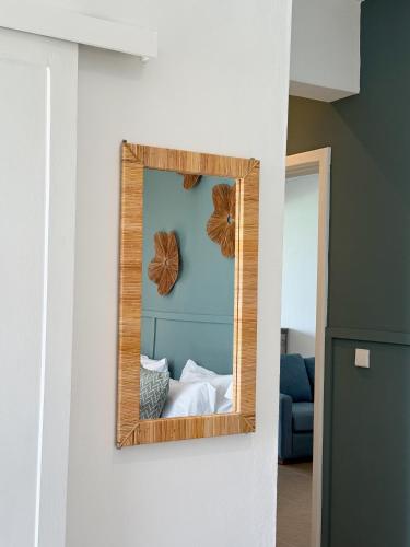 a mirror hanging on a wall in a room at Lorlagon 2-Bedroom Beachfront Apartment by LOV Mauritius in Trou d'Eau Douce