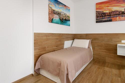 een slaapkamer met een bed en twee schilderijen aan de muur bij Gold - Il Centro Luxury Suites in Bari