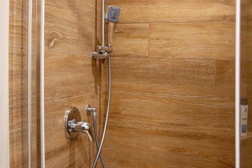 een douche in een houten wand met een douchekop bij Gold - Il Centro Luxury Suites in Bari