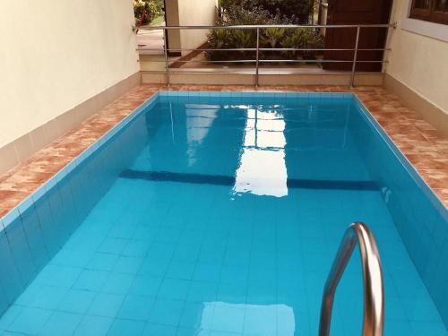une grande piscine bleue avec des carreaux bleus au fond dans l'établissement Lake View Bungalow Yala, à Tissamaharama