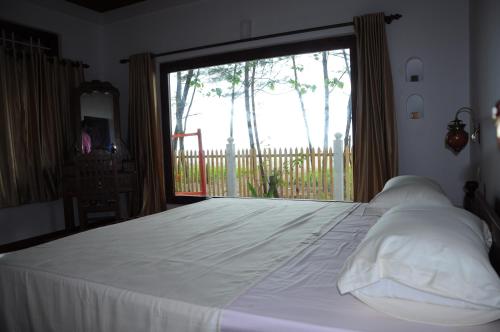 Postel nebo postele na pokoji v ubytování Alleppey Beach Garden
