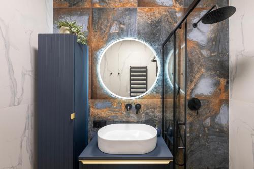 une salle de bain avec un lavabo et un miroir dans l'établissement Cottage Luxe Žaliakalnis, à Kaunas