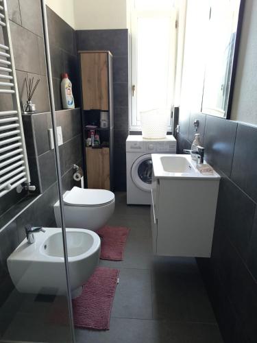 a bathroom with a sink and a washing machine at Appartamenti Lungo Fiume in Sesto Calende