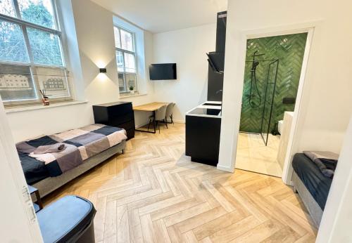 a bedroom with a bed and a desk in a room at Luxe studioappartement 2 gasten - 52-1 in Weener