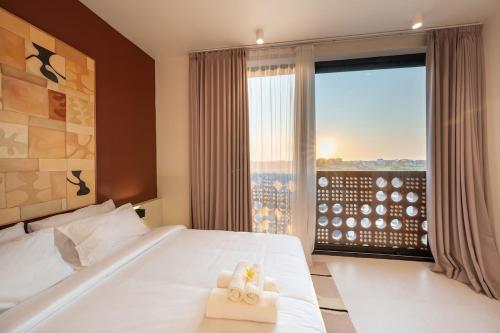 a bedroom with a bed and a window with a view at Gate 11 Spacious Apartment 1 Stylish 3rd Floor in Seminyak