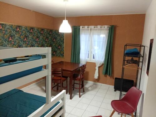 a bedroom with a bunk bed and a table and chairs at Ti'Kratèr Chambres d'hôtes in Le Tampon