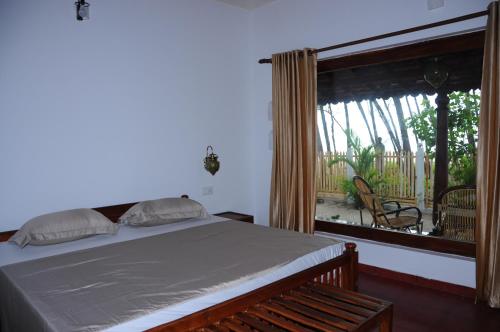 Postel nebo postele na pokoji v ubytování Alleppey Beach Garden
