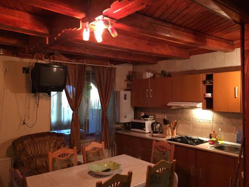 a kitchen with a table and a television and a kitchen with a tableablish at Casuta Paterau Cheia, Prahova in Cheia