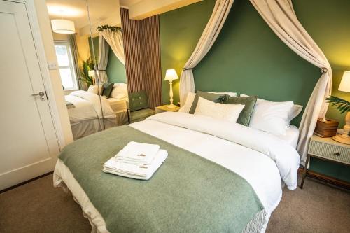 ein Schlafzimmer mit einem großen Bett mit einer grünen Wand in der Unterkunft 5 Star Luxury Apartment in the Heart of Galway City in Galway