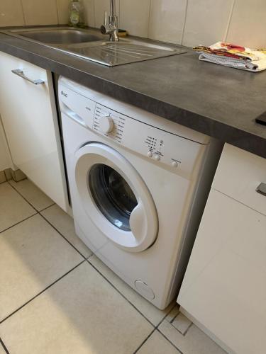 eine Waschmaschine in einer Küche mit Spüle in der Unterkunft Studieux in Millau