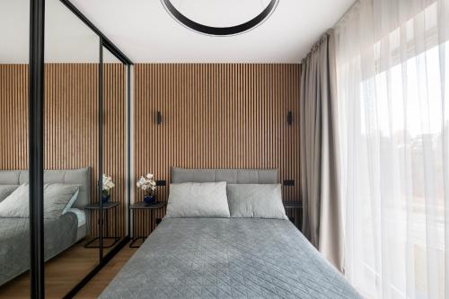 une chambre avec un lit et une grande fenêtre dans l'établissement Cottage Luxe Žaliakalnis, à Kaunas