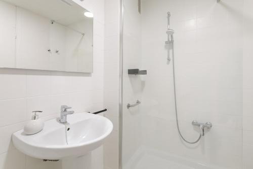 a white bathroom with a sink and a shower at Mar 4 en Santa Pola in Santa Pola