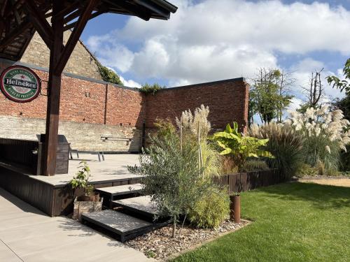 a garden with a brick building and a bench at A l'ancienne boulangerie, proche de Colmar et des plus beaux villages en Alsace in Meyenheim