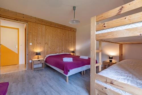 a bedroom with two bunk beds and wooden walls at L'Eco-logis du Clos Des Tilleuls in Molieres-Glaudaz