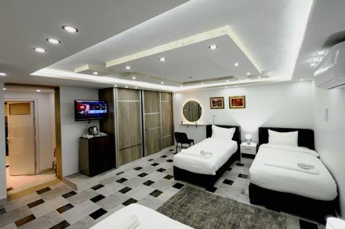 a hotel room with two beds and a television at Rose In Apartment in Wadi Musa