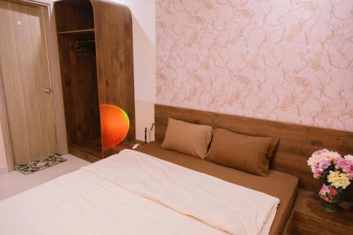 - une chambre avec un lit orné de fleurs sur le mur dans l'établissement Châu Giang Luxury -Nera Garden APartment 2-3 Bedroom, FREE hồ bơi, à Hue