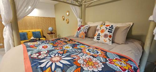 a bedroom with a bed with a floral bedspread at Hotel pretty rooms in Pak Kret
