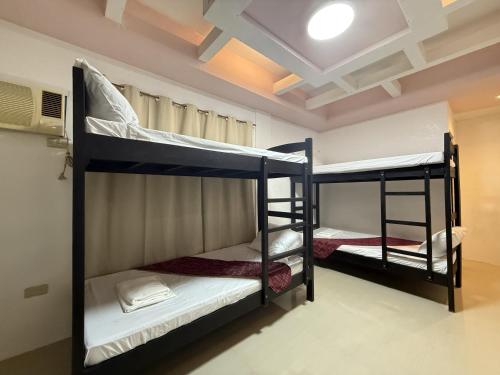 プエルト・プリンセサにあるCozy Stop Inn - Puerto Princesaの天井のドミトリールームの二段ベッド2台分です。