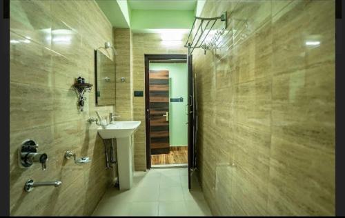 ein Badezimmer mit Waschbecken und Dusche in der Unterkunft Padmashree Hotel & Spa in Darjeeling