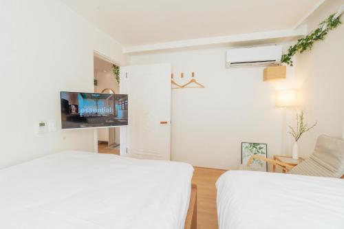 Un dormitorio blanco con dos camas y un televisor. en new 하루 온 올리모델링 청결중시 잠실 롯데월드 올림픽공원 성수 강남, en Seúl