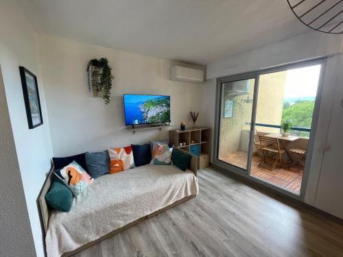 ein Wohnzimmer mit Couch und großem Fenster in der Unterkunft Azur Bay Boho-Chic T2 Garage & Mer Pet-Friendly in La Ciotat