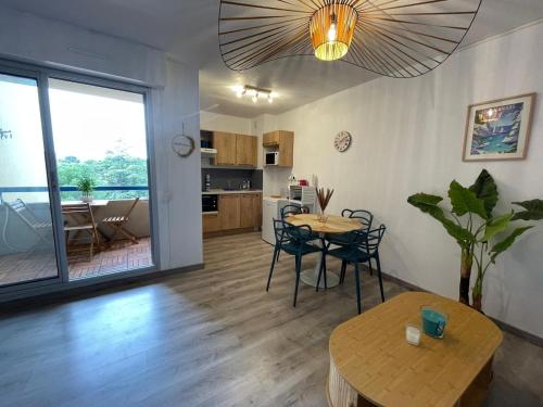 ein Wohnzimmer mit Tisch und Küche in der Unterkunft Azur Bay Boho-Chic T2 Garage & Mer Pet-Friendly in La Ciotat