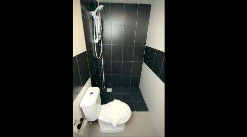 a bathroom with a toilet and a phone on the wall at Vitro Hotel in Johor Bahru