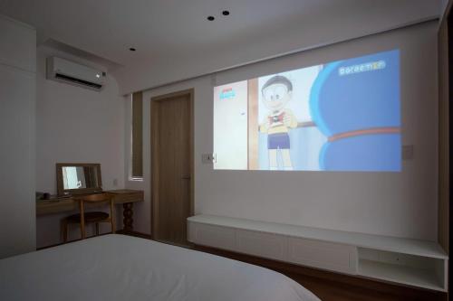 eine Leinwand in einem Zimmer mit einem Bett in der Unterkunft Adory Homestay Huế in Hue