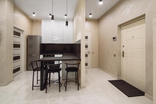 une cuisine avec une table et des tabourets dans une pièce dans l'établissement АПАРТАМЕНТЫ МОРЕе, à Odessa