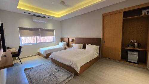 a hotel room with two beds and a television at Central Residence by Paramount Hospitality in Karachi