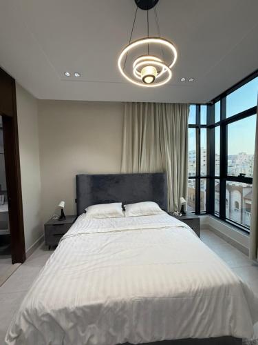 ein Schlafzimmer mit einem großen Bett mit einem großen Fenster in der Unterkunft سكاي هوم السلامة in Dschidda