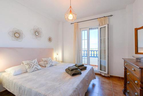 a bedroom with a large white bed with a balcony at Vista Marina de Isla Canela in Isla del Moral