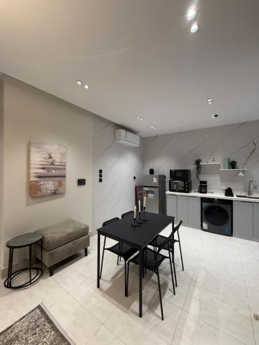 eine Küche und ein Esszimmer mit Tisch und Stühlen in der Unterkunft سكاي هوم السلامة in Dschidda