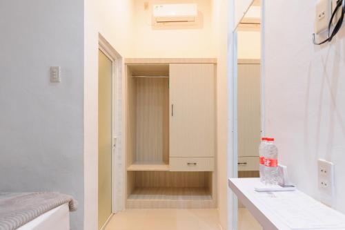 a room with a closet with a sink and a mirror at Urbanview Hotel Brodam's Pematang Siantar by RedDoorz in Pematangsiantar