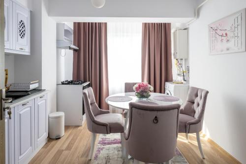 een keuken met een tafel en stoelen in een kamer bij Apartament de închiriat Accommodation Ap 9 in Suceava