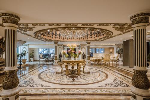 a large lobby with a chandelier and a table with flowers at Sonesta St George Nile Cruise - Luxor to Aswan 4 Nights from Monday to Friday in Luxor