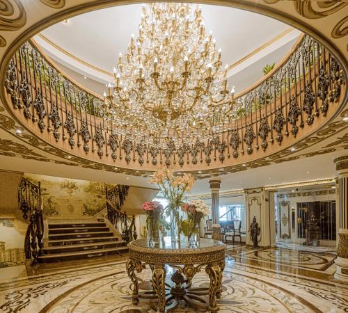 a large room with a chandelier and a table with flowers at Sonesta St George Nile Cruise - Luxor to Aswan 4 Nights from Monday to Friday in Luxor