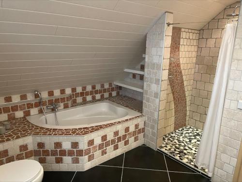 a bathroom with a tub and a toilet at Wellness-Villa-Eifel 3 Schlafzimmer in Mechernich