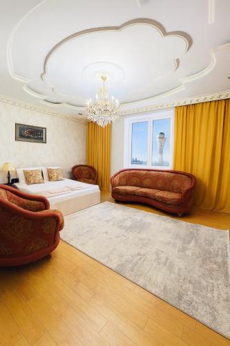 - un salon avec deux canapés et un lit dans l'établissement 390 Очень теплая квартира с видом на Байтерек с 2 большими кроватями и 2 санузлами, à Astana