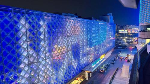 ein Gebäude mit Lichtern an der Seite in der Nacht in der Unterkunft Hongqiao Aegean Sea LOFT Apartment in Shanghai