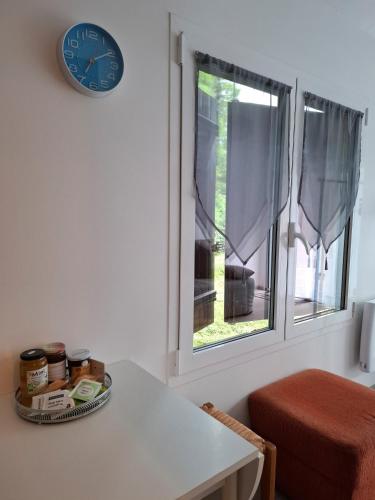 a clock on a wall next to a window at Jardin Fleuri - Proche Foix in Saint-Paul-de-Jarrat