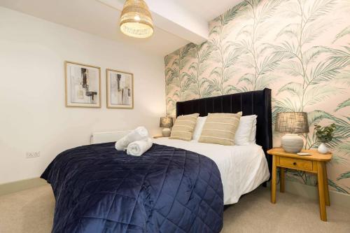 a bedroom with a large bed with a blue comforter at Relaxed, Spacious & Ideal for Small Families in Bournemouth