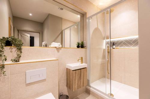 a bathroom with a shower and a sink and a mirror at Relaxed, Spacious & Ideal for Small Families in Bournemouth