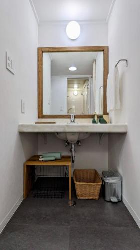 a bathroom with a sink and a mirror at Prince Plage Okinawa 406 PP46 in Fuzuchi