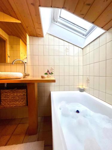 a bath tub in a bathroom with a skylight at Castle and Alps Appartement in Halblech