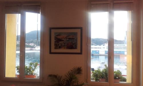 three windows in a room with a view of the water at Appartement La Méditerranée vue sur la Mer in Port-Vendres