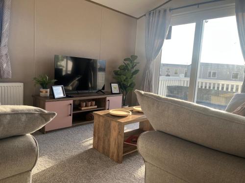 ein Wohnzimmer mit Sofa und Fernseher in der Unterkunft NEW 2025 Modern 3Bedrooms Lodge Walk to Beach in Morecambe