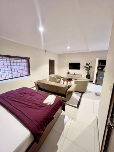 ein Schlafzimmer mit Bett und ein Wohnzimmer in der Unterkunft Elegant Studio Haven Offering Peace, Comfort & Style in Mama