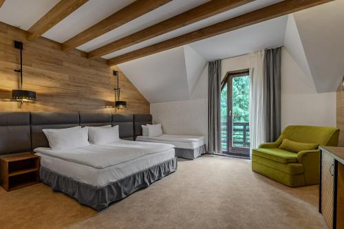 a bedroom with a bed and a green chair at Bukovel Hotel in Bukovel