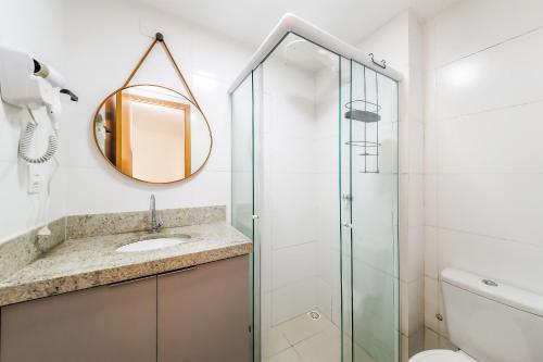 a bathroom with a shower and a sink and a mirror at Studio Novo com ar ao lado da Igreja São Mateus in Juiz de Fora